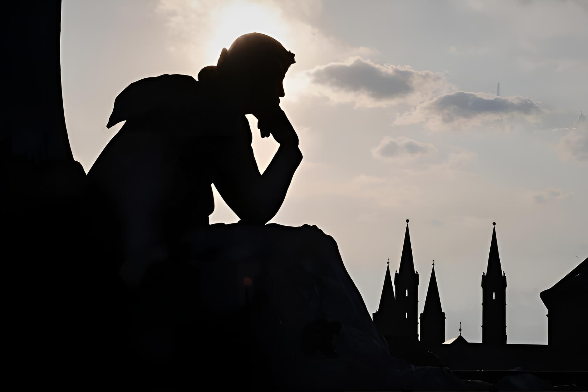 Silhouette of a contemplative statue against a sunset sky, church steeples rising in the distance — quiet, reverent, and a little suggestive of what’s coming.